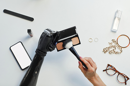 High angle view of woman with disability applying blush with brush at table