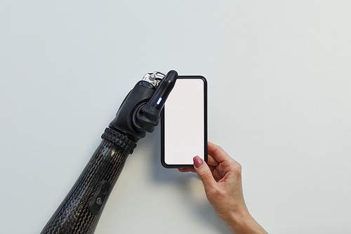 High angle view of girl with prosthetic arm using mobile phone on white background