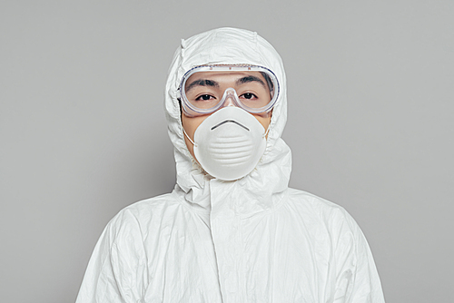 asian epidemiologist in hazmat suit and respirator mask  on grey background