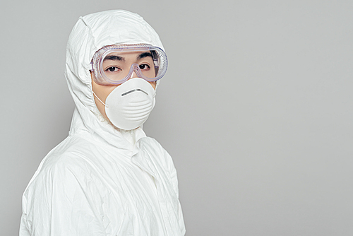 asian epidemiologist in hazmat suit and respirator mask  isolated on grey