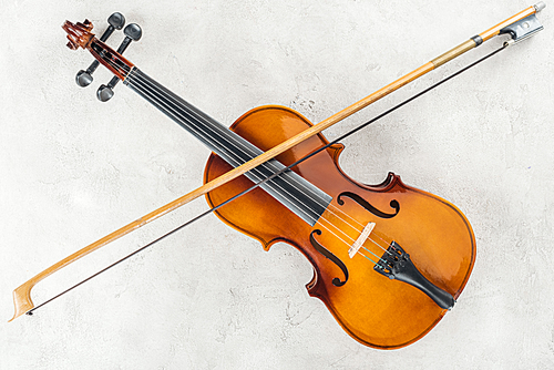 top view of classical cello with bow on grey background