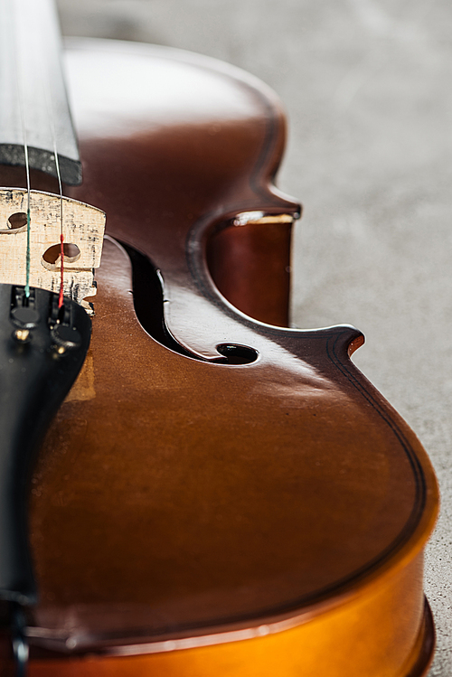 close up of classical wooden cello on grey textured background