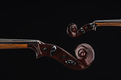 close up of classic wooden cello with bow isolated on black