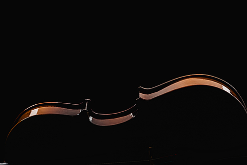 close up of wooden violoncello in darkness isolated on black