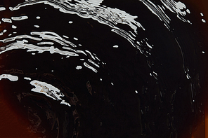 Close up view of dark background with liquid texture