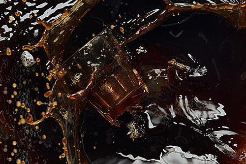Overturned glass with black coffee, big splash and drops