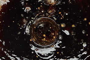 Top view of glass and black coffee with drops