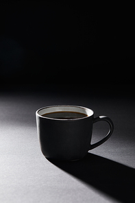 Coffee cup on dark textured surface on black