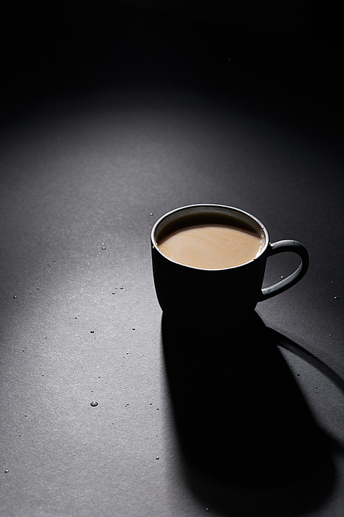 Cup of coffee with milk on dark textured surface