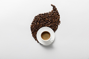 top view of coffee in cup near leaf made of coffee grains on white background