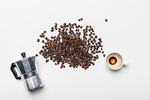 top view of aluminium coffee pot, scattered coffee grains and cup on white background