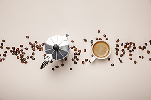 top view of metal coffee pot, coffee beans and cup on beige background