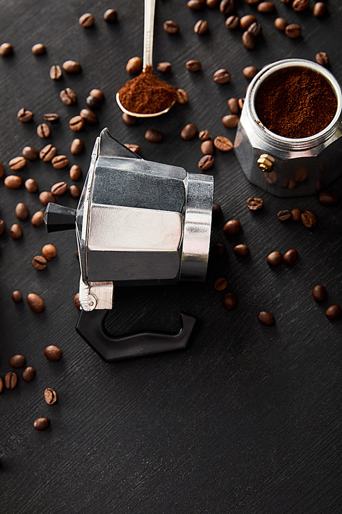 Separated parts of geyser coffee maker near spoon on dark wooden surface with coffee beans