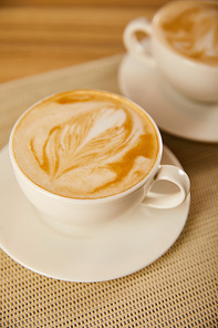 selective focus of tasty cappuccino in white cups on table