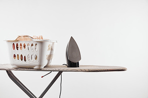 Ironing board, laundry basket and iron isolated on white