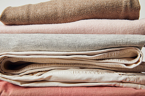 Close up view of stack of folded ironed clothes on grey