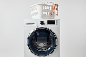 Washing machine with laundry basket isolated on grey