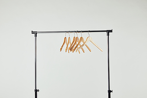 Steel straight rack with wooden hangers isolated on grey