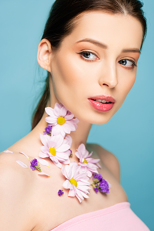 young woman with flowers on neck isolated on blue