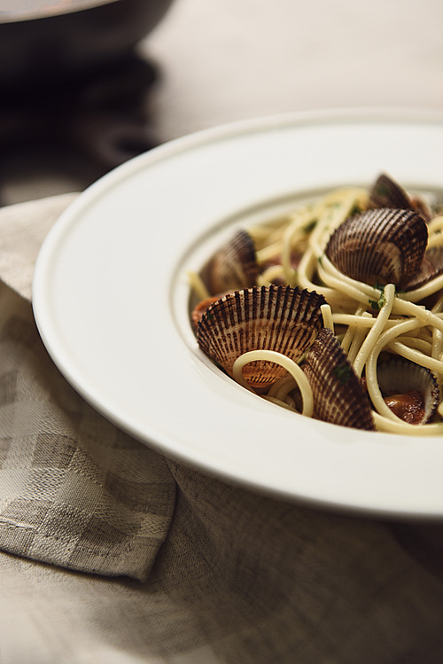 close up view of delicious pasta with mollusks on napkin