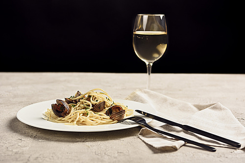delicious Italian spaghetti with seafood served with white wine isolated on black