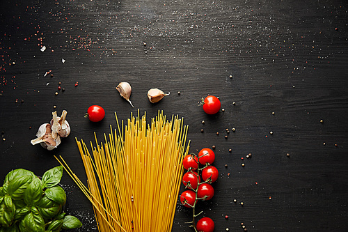 top view of raw bolognese pasta ingredients on black wooden background