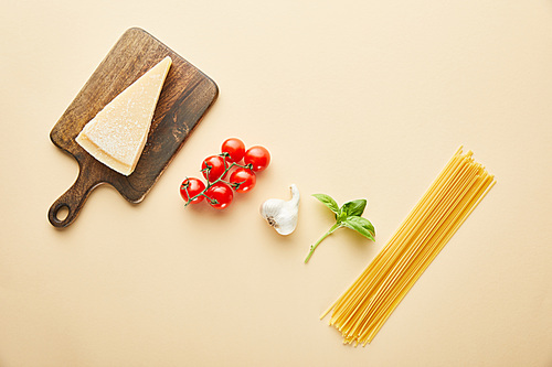 flat lay with delicious spaghetti with tomato sauce ingredients on yellow background