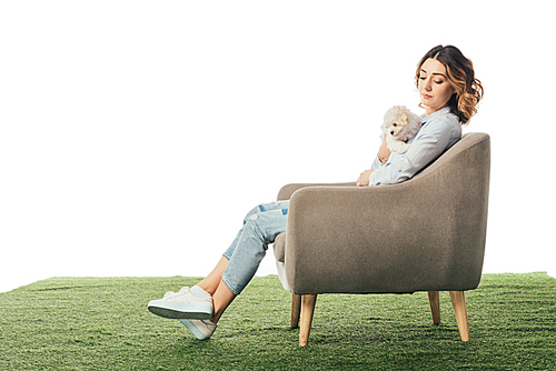 woman holding Havanese puppy and sitting on armchair isolated on white