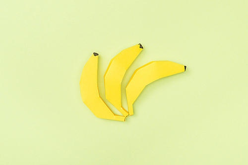 top view of yellow paper bananas isolated on green
