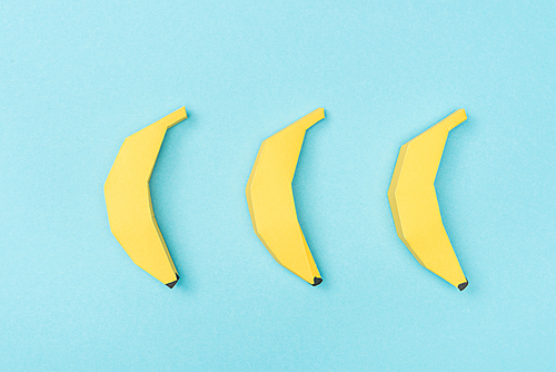 top view of arranged yellow paper bananas Isolated On Blue