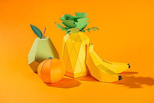 handmade paper pineapple, bananas, pear and tangerine on orange
