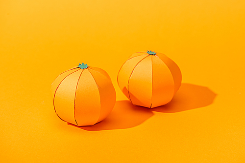 handmade tangerines made of paper on orange with shadow
