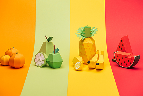 various handmade paper fruits on stripes of colorful paper