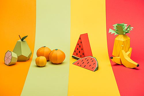 various handmade origami fruits on stripes of colorful paper