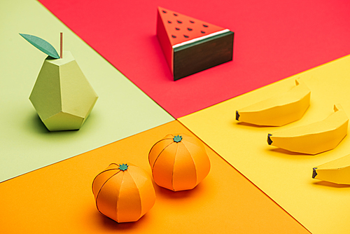 origami watermelon, pear, tangerines and bananas on colorful paper