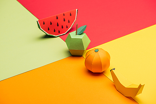 origami watermelon, apple, tangerine and banana on colorful paper