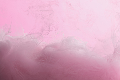 Close up view of pink paint mixing in water isolated on pink