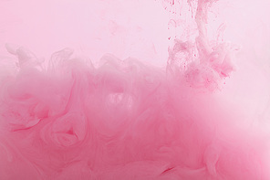Close up view of pink paint mixing in water