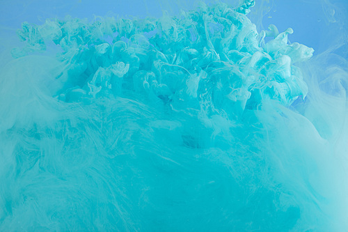 Close up view of turquoise smoky paint swirls isolated on blue