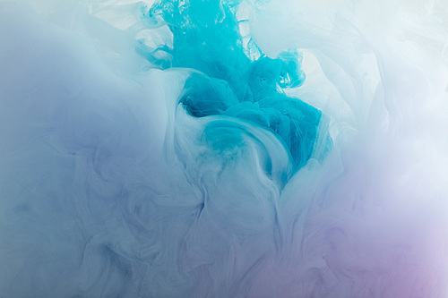 Close up view of blue and purple paint swirls in water