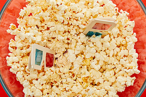 top view of delicious popcorn in glass bowl with 3d glasses