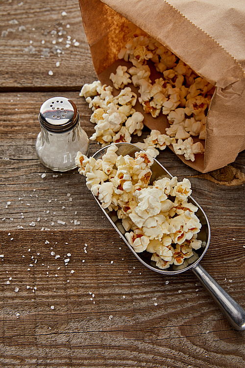 top view of salty popcorn scattered on wooden background