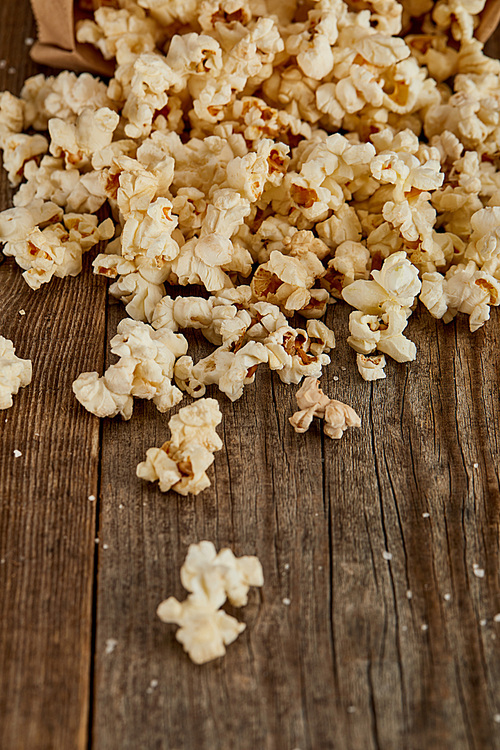 delicious popcorn scattered on wooden background