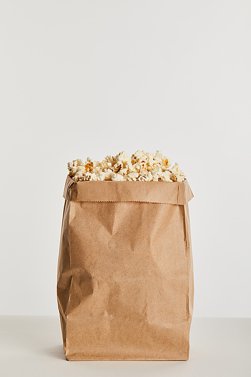 delicious popcorn in paper bag isolated on grey