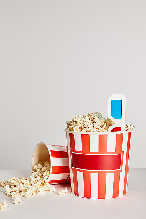 tasty fresh popcorn in buckets with 3d glasses isolated on grey