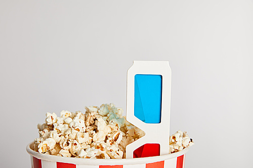tasty fresh popcorn in paper bucket with 3d glasses isolated on grey
