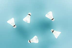 white badminton shuttlecocks with feathers on blue