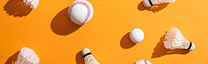 panoramic shot of shuttlecocks with feathers near softball and golf ball on yellow
