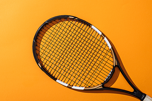 top view of black tennis racket on yellow