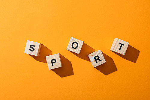 top view of wooden cubes with sport letters on yellow